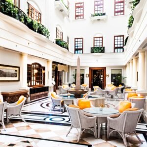 Ornate hotel lobby with high ceilings, chandeliers, polished floors, and vintage furniture at The Imperial New Delhi